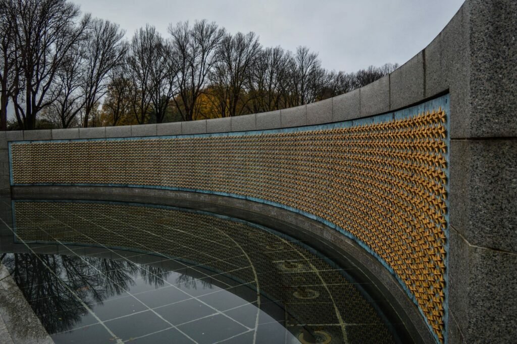 memorial wall decorated with golden stars in park on rainy day