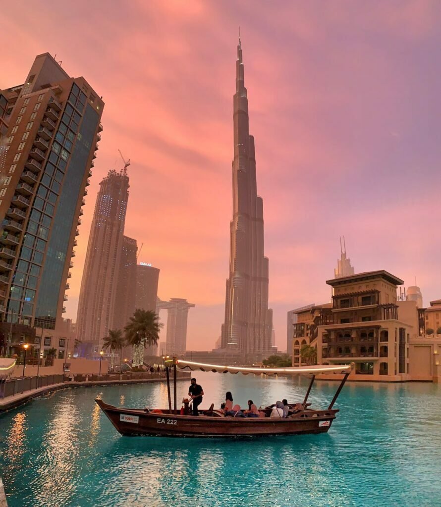 people riding a boat near the burj khalifa in dubai uae